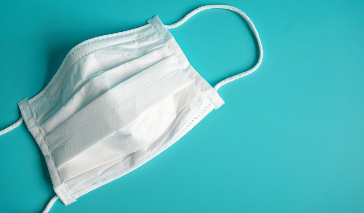White surgical mask on a blue background.