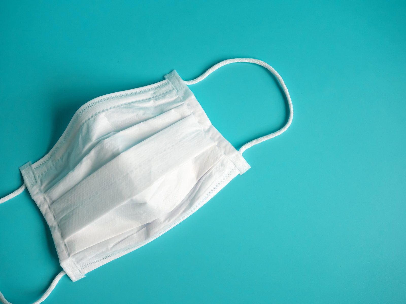 White surgical mask on a blue background.