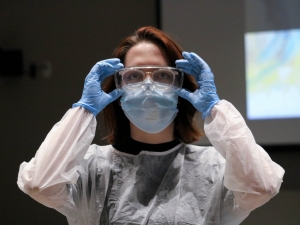 Rosemarie Moretti strikes a tableau pose as a nurse dressed in personal protective equipment.