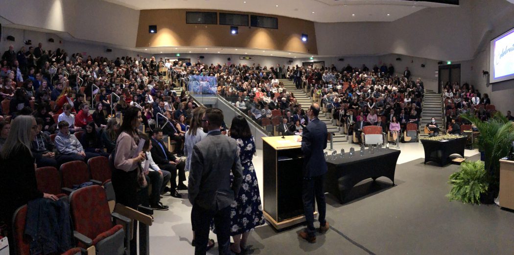 A group of high school students and parents in a lecture hall at Brock University.