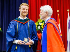 A graduate receives an award on stage at Brock University's Convocation.