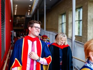 Kyle Dubas walks into Brock's Convocation ceremony with Brock faculty members and guests.