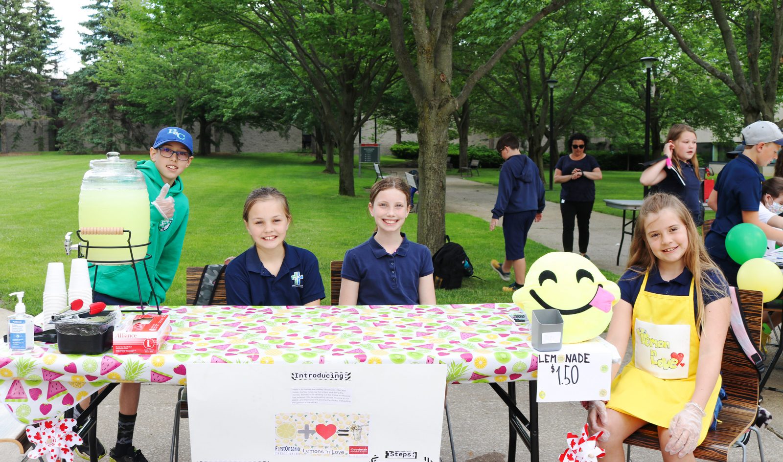 A group of elementary school students selling lemonade outside.
