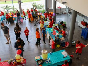 Groups of elementary school students set up lemonade stands at Brock University in a large sunny atrium.
