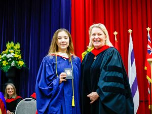 An award-winning graduate stands beside the Dean of Brock University's Faculty of Social Sciences during a graduation ceremony.