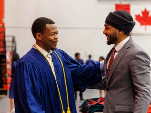 Two men congratulate each other before a Brock University Convocation ceremony.