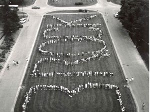 An aerial view of people standing in the shape of the words 