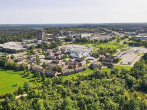 An aerial view of Brock University's main campus surrounded by greenery.