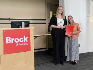 Amanda Leonetti, PhD candidate in Biological Sciences, receives a NORGEN Rising Star Award from a NORGEN representative.