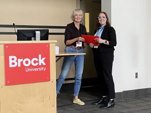 Brock University Faculty of Mathematics and Science Associate Dean Cheryl McCormick presents Francine Burke, PhD in Neuroscience candidate, with a second-place award for her oral presentation.