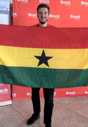 A university student holds the flag of Ghana.