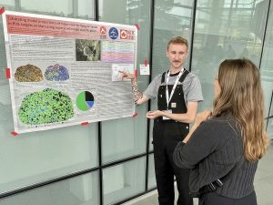 Brock University graduate student Josh Labrie points to a poster presentation about his research while speaking with fellow student Georgina Gardner.