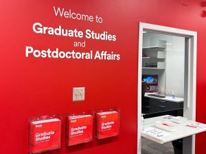 A red wall with the writing WWelcome to Faculty of Graduate Studies and Postdoctoral Affairs" on it.