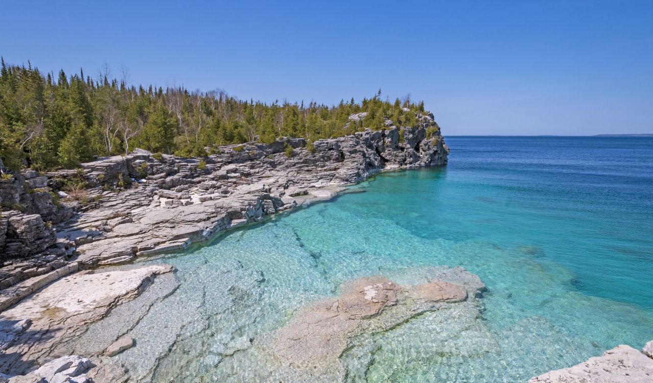 Cliffs overlook clear water in a cove in Bruce Peninsula National Park in Ontario.