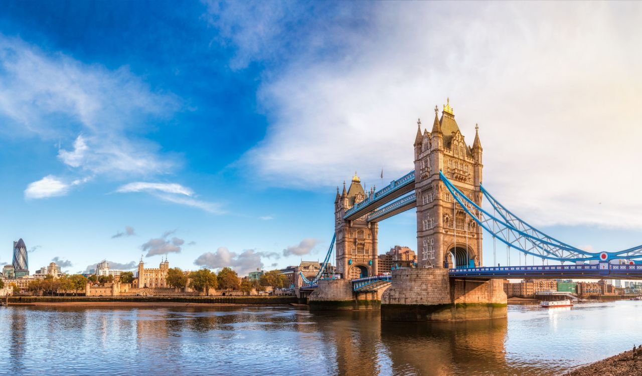 Panoramic London skyline with Tower Bridge and the Tower of London as viewed from South Bank of the River Thames in the morning light.