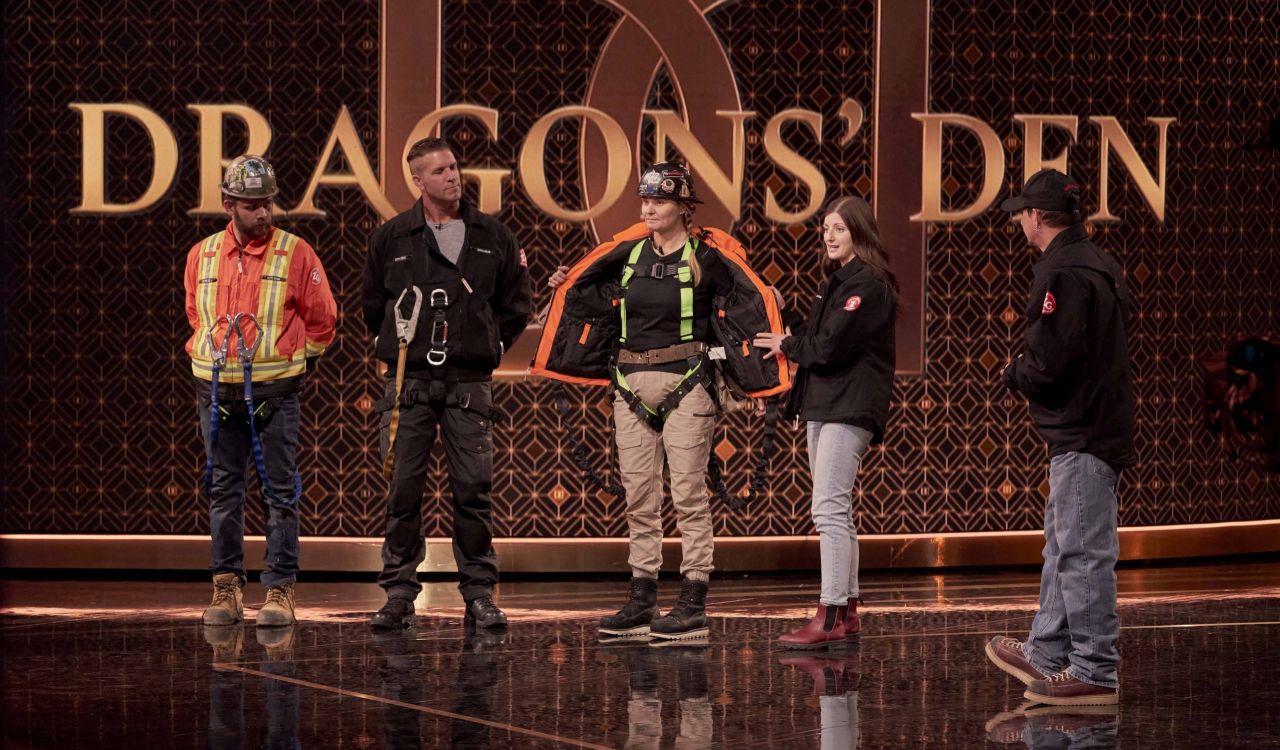 On the set of the TV show Dragons’ Den, three models wear safety gear as Cecily Zeppetella and Pete Zeppetella speak to the judges, not shown.