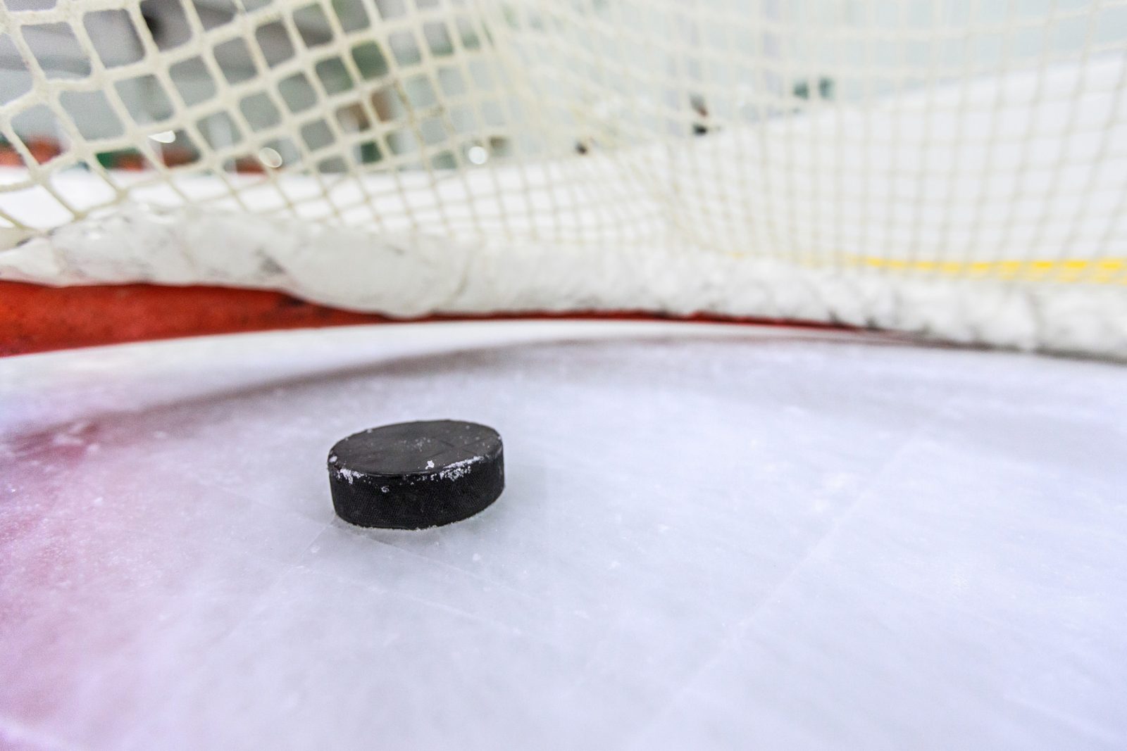 Hockey net with puck in goal.