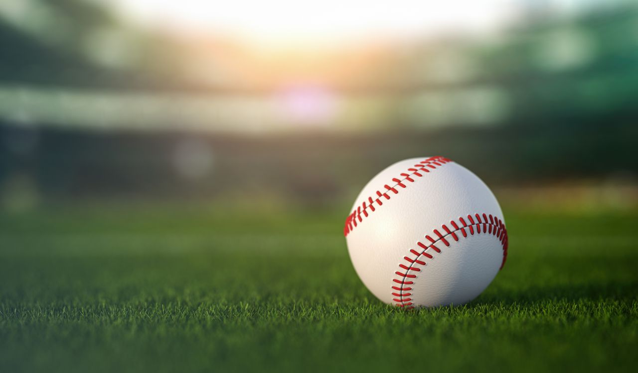 Baseball ball on grass in a baseball stadium.