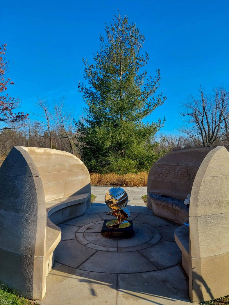 A bronze globe sculpture sits at the centre of the two distinctive curvilinear walls that make up the First Nations Peace Monument.