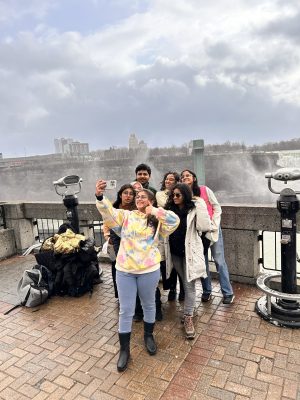 A group of university students poses for a selfie in front of Niagara Falls.