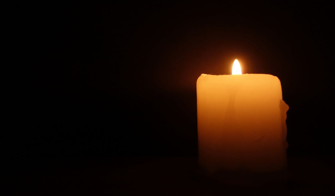 A lit candle on a black background.