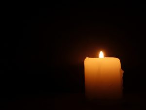 A lit candle on a black background.