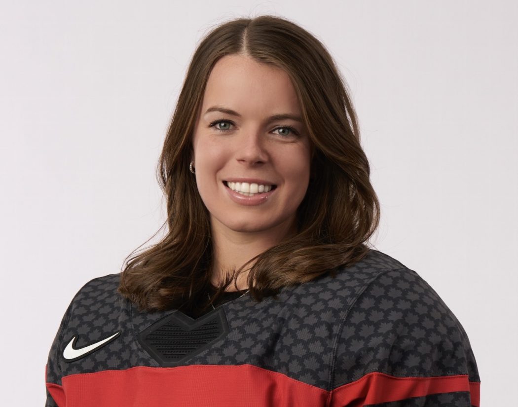 Brock student and professional hockey player Victoria Bach smiles warmly while wearing a Team Canada red and black jersey against a white background.