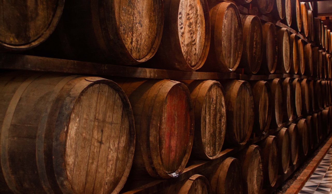 Wine barrels sit stacked in a wine cellar.