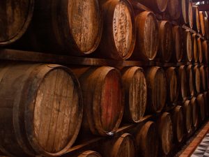 Wine barrels sit stacked in a wine cellar.