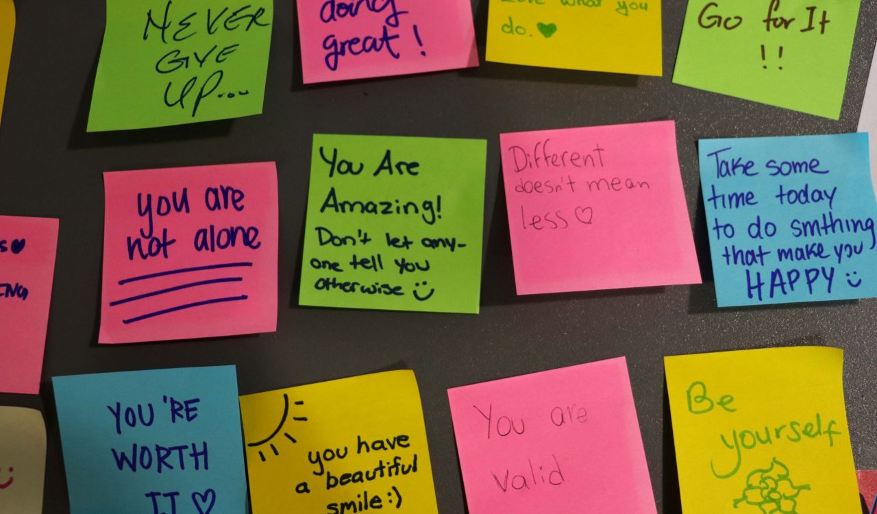 Colourful sticky notes with encouraging messages written on them.