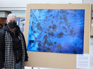 Laurie Morrison poses next to “Interactions” at the first annual World Water Day Celebration.