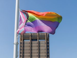 A pride flag flies in front of the Brock Schmon Tower.