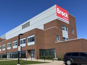 A photo of the Brock University International Centre building exterior in front of a blue sky on a sunny day.