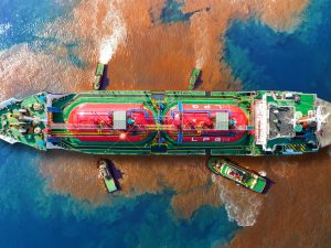 An aerial view of an oil tanker spilling oil into the sea.