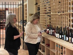 Ontario’s Minister of Agriculture, Food and Rural Affairs Lisa Thompson examines a bottle of wine in Brock’s wine cellar as Cool Climate Oenology and Viticulture Institute Director Debbie Inglis looks on.