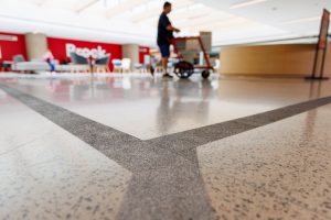 Grey accessibility vision lines run across floor in a brightly lit space at Brock University.