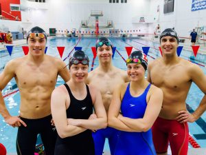 A group of swimmers stand proudly in front of Brock University’s Olympic size pool.