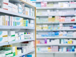 Aisle in a drugstore showing medications and pharmaceutical drugs stocked on shelves.