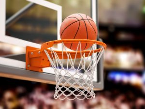 A close-up of a basketball ball going through a hoop.