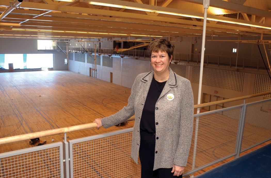 A woman stands on a track high above a gymnasium court at Brock University.