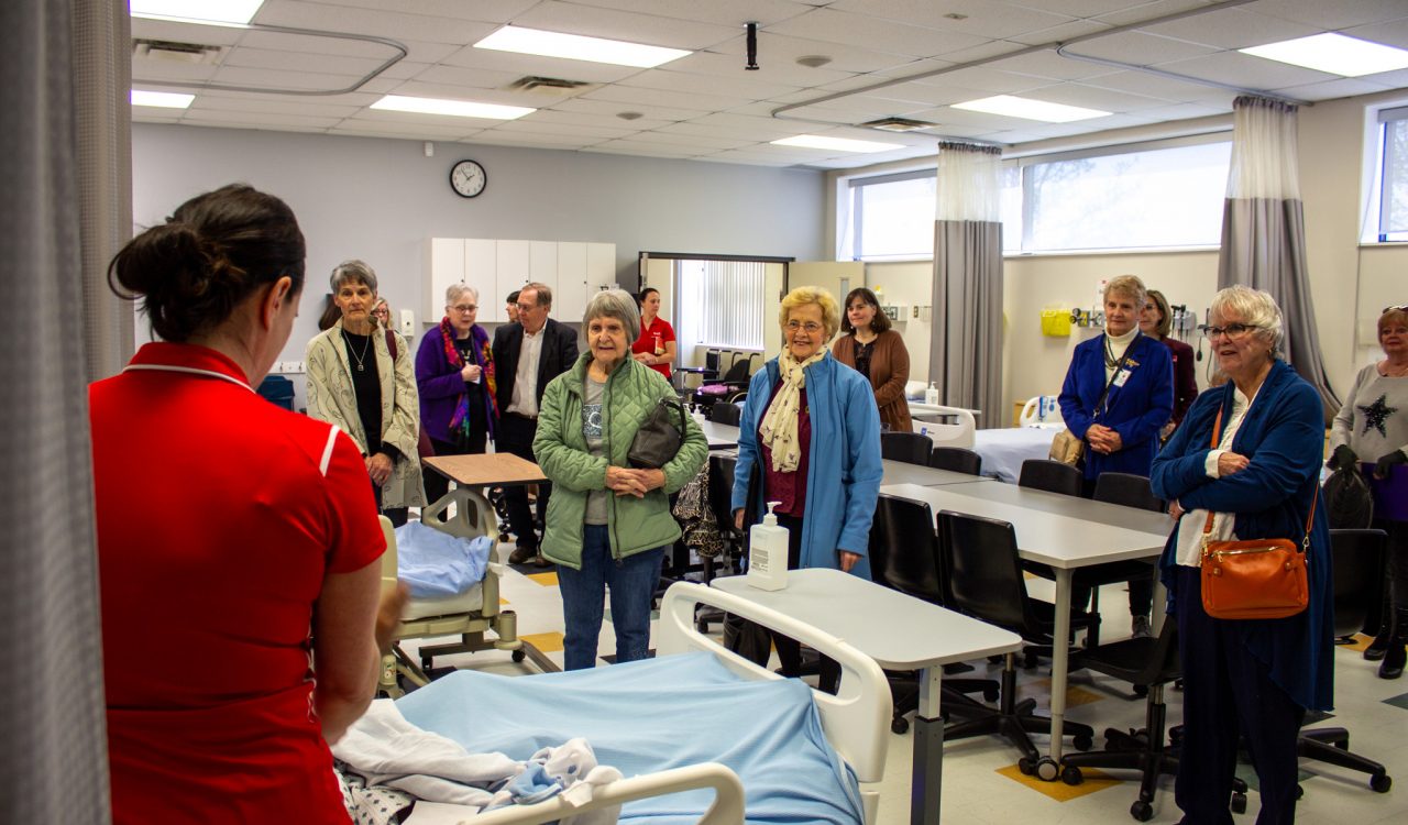 A group of people in a simulated hospital room.