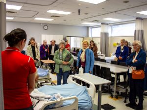 A group of people in a simulated hospital room.