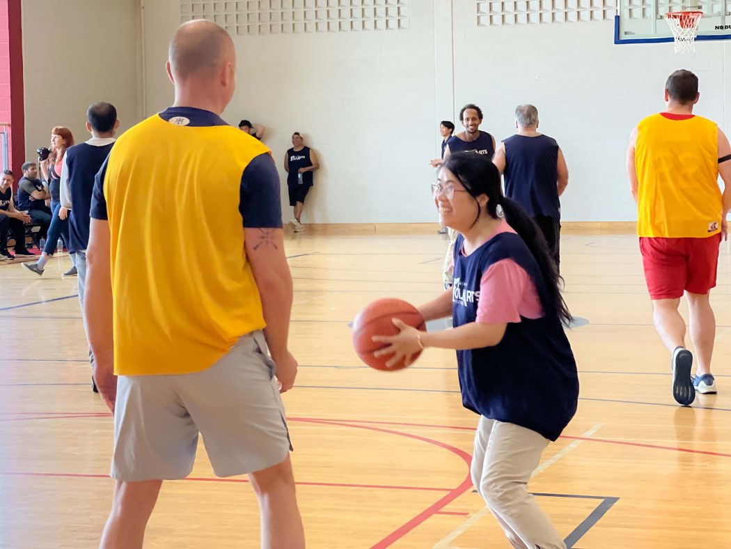 A man and a woman play basketball. 