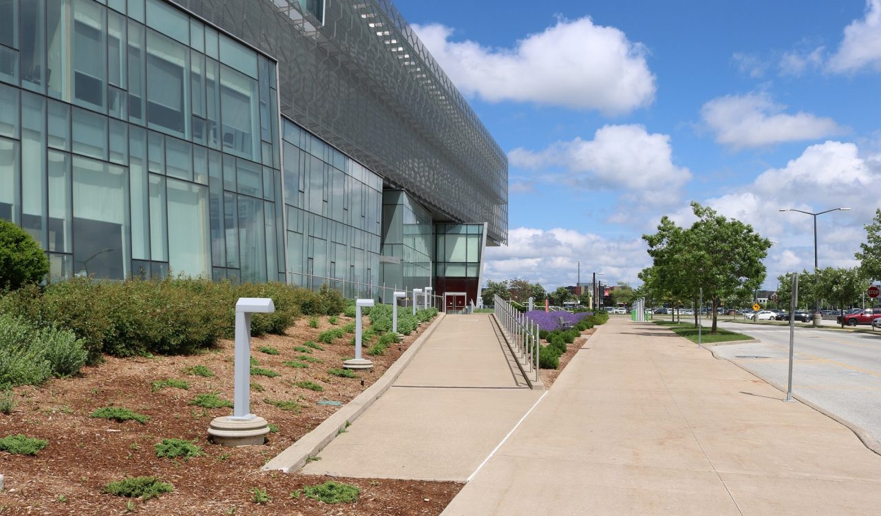 A photo of the ramp leading up to the entrance to Brock University’s Roy and Lois Cairns Health and Bioscience Research Complex building.