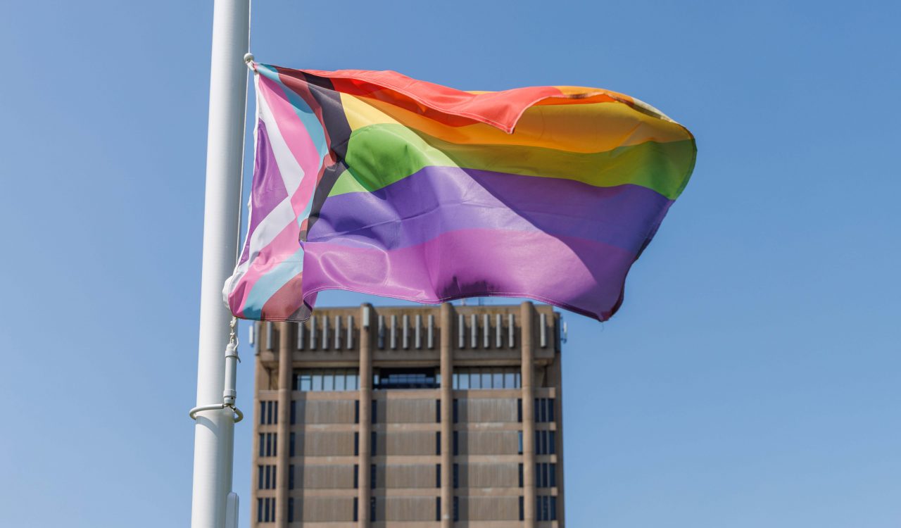 Brock University’s all-inclusive flag representing 2SLGBTQ+ communities flies in front of the Schmon Tower.