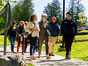 A group of academic leaders walk along an outdoor path at Brock University.