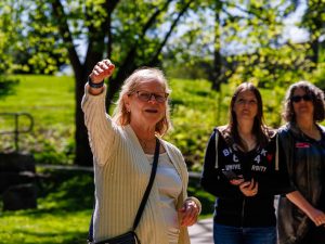 A professor speaks to a group during an outdoor tour of Brock University.