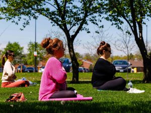 Brock University employees take part in an outdoor yoga session among cherry blossom trees and sunny weather.