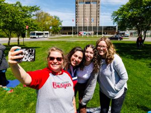 Brock University employees take part in an outdoor yoga session among cherry blossom trees and sunny weather.