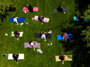 Brock University employees take part in an outdoor yoga session among cherry blossom trees and sunny weather.